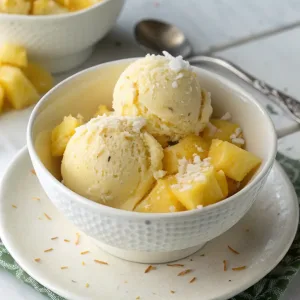 Easy Pineapple Coconut Sorbet with tropical flavors, garnished with mint and shredded coconut.