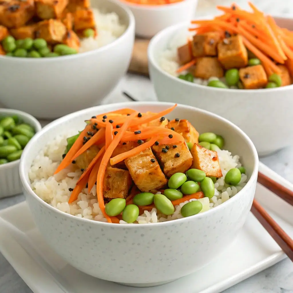Sweet Chili Tofu Rice Bowl with Edamame and Carrots - Easy Quick Recipe - Easy Quick Recipe A colorful rice bowl topped with sweet chili glazed tofu, shredded carrots, edamame, and green onions